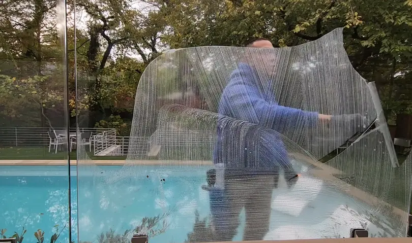 Cleaning a Frameless Glass Panel Worker cleaning a frameless glass pool fence panel