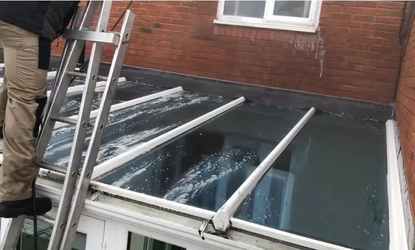 Ladder Access for Glass Roof Cleaning Ladder set against a glass roof so the panels can be cleaned without standing on the glass