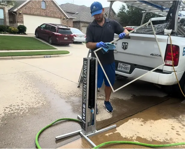 Screen Rinsing Setup in a Driveway Technician rinsing with a hose beside a work truck and water cart in a residential driveway