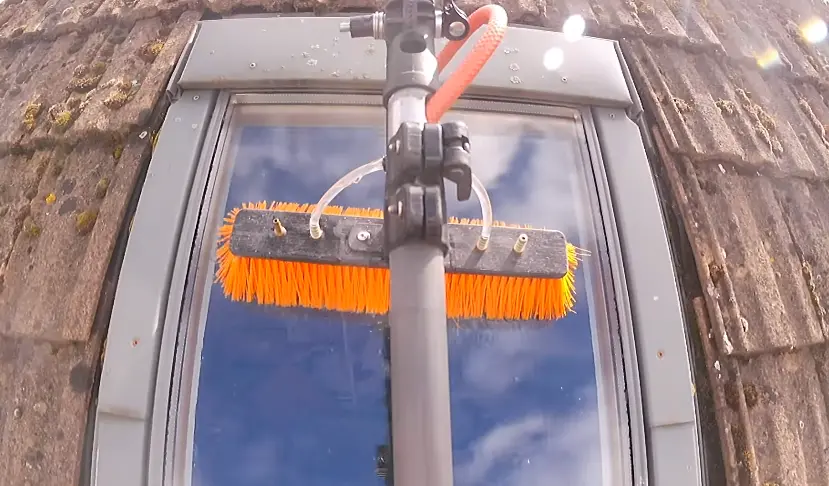 Water-Fed Pole Cleaning an Upper Window Glass Cleaning Services Bellingham: window cleaner using a water-fed pole on an upper-story window
