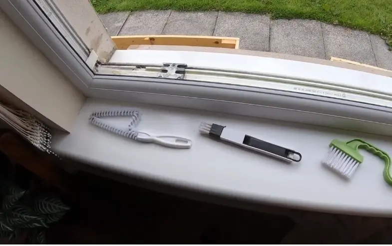 Window Cleaning Tools on a Sill Squeegee, scrubber and detail tools laid out on a window sill before cleaning