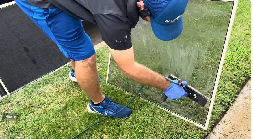 Window Screen Cleaning on the Lawn Screens, Tracks and Sills Bellingham: window cleaner scrubbing a removed window screen laid flat on a lawn